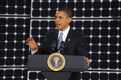 Obama spricht vor einer Solarwand.