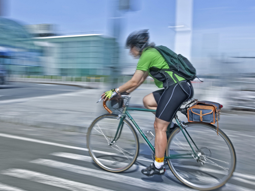 Ein Fahrradfahrer fährt schnell durch die Stadt.