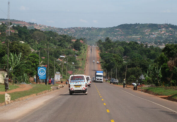 Eine Straße führt durch die hügelige Landschaft in Uganda.