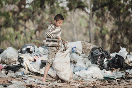 Armes Kind inmitten von Müllbergen