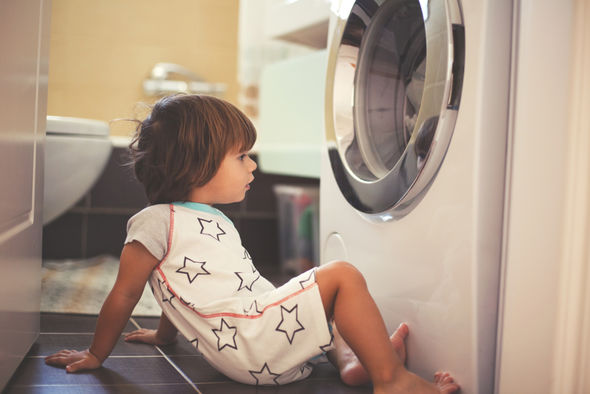Kind vor Waschmaschine.