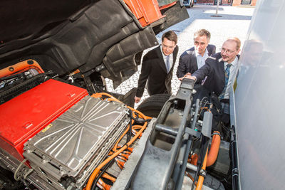 V.l.: Gesamtprojektleiter Prof. Dr. Boris Zimmermann, Praxispartner Markus Bappert, Geschäftsführer Meyer Logistik, und technischer Projektleiter Prof. Dr. Wolfgang Geuer beim Blick in den Motorraum des E-LKW. Das Fahrzeug ist im Rahmen des Forschungsprojekts für die Spedition Meyer Logistik (Friedrichsdorf) im Einsatz.