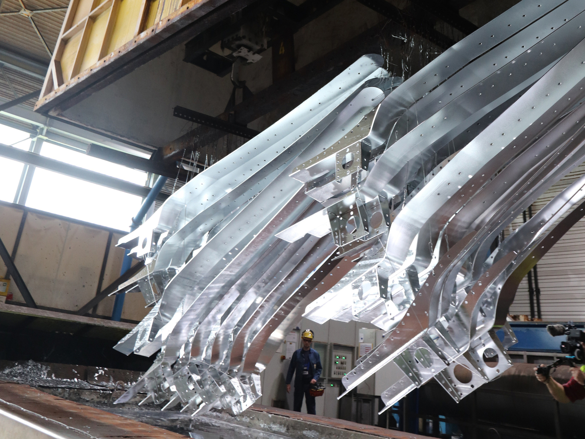 Eine Traverse zieht Stahlteile aus einem über 400 Grad heißen Zinkbad im Stahlverzinkungsbetrieb ZINQ am Standort Hagen.