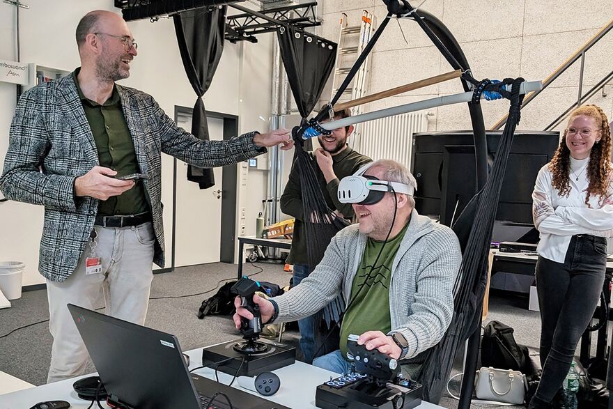 Prof. Dr. Uwe Sponholz (li.) und Frank Wenzhöfer (2. v. re.) testen die VR-Anwendung im MAVEL-Lab in Schweinfurt