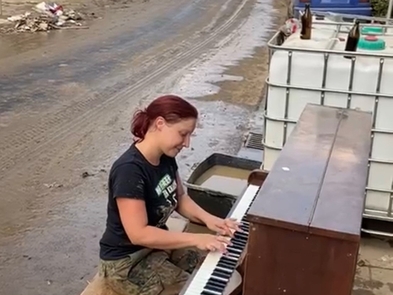 Am Abend eines langen Arbeitstages spielte plötzlich eine junge Frau ein Ständchen auf ihrem Klavier, mitten auf der Straße vor ihrem vom Hochwasser schwer gezeichneten Haus. Ein Moment der sich allen ins Herz brannte