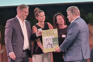 Carsten Träger, Parlamentarischer Staatssekretär im BMUKN, und Florian Pronold, Geschäftsführer des Instituts Bauen und Umwelt (IBU), überreichen die erste RCD an das Stahlunternehmen voestalpine. 