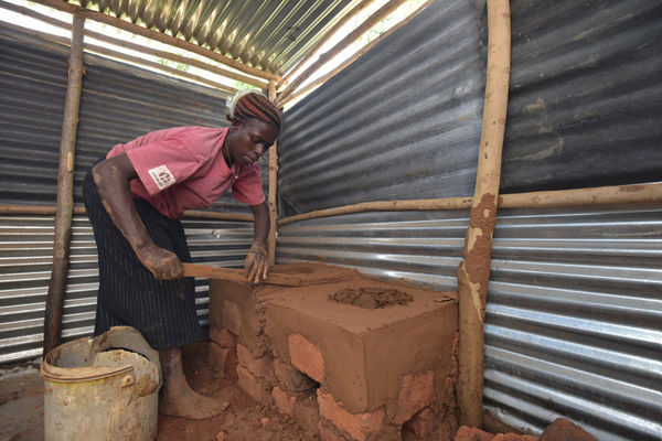 Eine Frau in Kenia kocht an ihrer neuen Feuerstelle