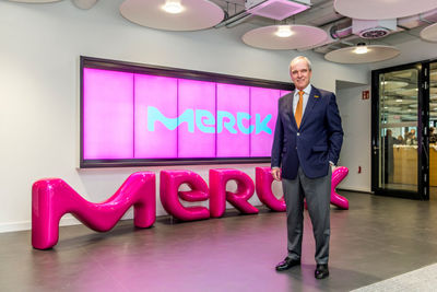 Karl-Ludwig Kley, Vorsitzender der Geschäftsleitung & CEO von Merck vor dem neuen Merck Logo.