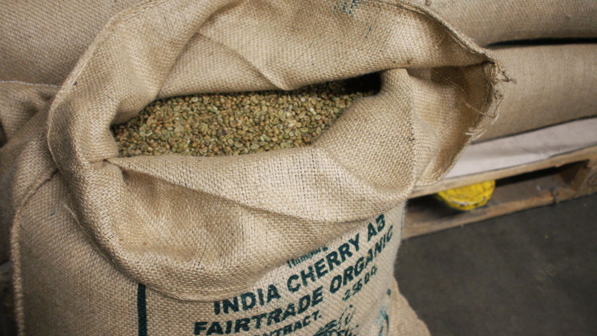 Rohe Kaffeebohnen in einem offenen Jutesack