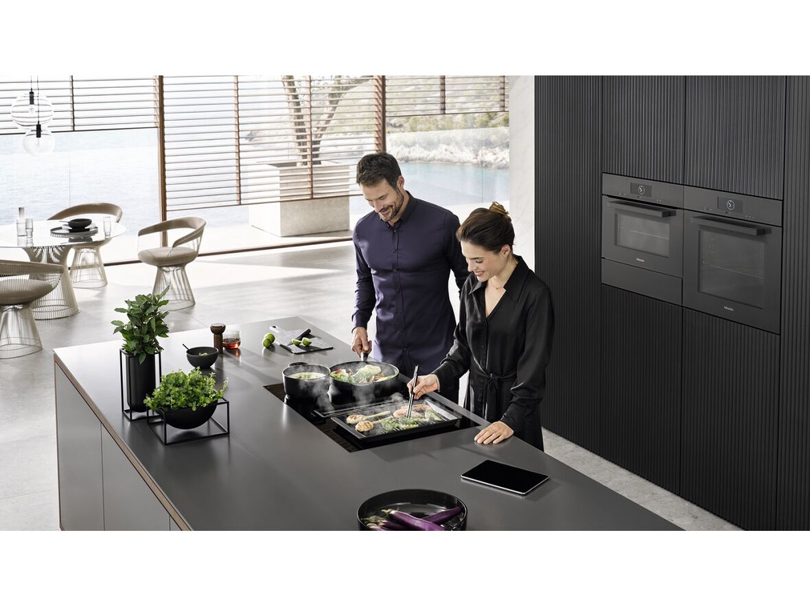 Die Miele Einbaugeräte der Generation 7000 in Aktion (hier: Das Induktionskochfeld TwoInOne mit integriertem Dunstabzug).