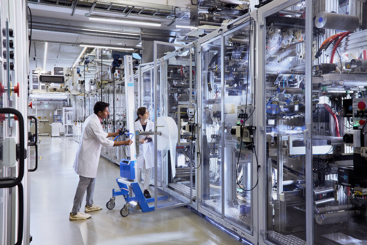 Mitarbeiter bestücken die Pampers-Testproduktionslinie.