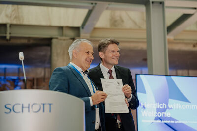 Landrat Roland Grillmeier überreicht die Genehmigung für die neue E-Wanne an SCHOTT-CEO Dr. Torsten Derr (rechts).
