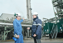 Dr. Klaus Jaeger (r.), Leiter des Standortverbundes NRW bei Bayer MaterialScience, und Stefan Sobek, Produktionsmeister bei INEOS, vor der modernisierten Salpetersäureanlage in Dormagen. Foto: Bayer MaterialScience AG